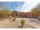 Beautiful southwestern home with desert landscaping, arched entry, and spacious driveway leading to a three-car garage at 35195 N 98Th St # 85, Scottsdale, AZ 85262