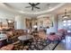 Open living room with large windows, a stone fireplace, and luxurious furnishings at 35195 N 98Th St # 85, Scottsdale, AZ 85262