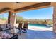 Comfortable covered patio featuring ample seating, stone accents, and serene views of the backyard oasis at 35195 N 98Th St # 85, Scottsdale, AZ 85262