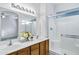 Bathroom with double sinks, wood cabinets, glass shower, and natural light at 3640 E Torrey Pines Ln, Chandler, AZ 85249