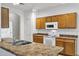 Kitchen with wood cabinets, tile backsplash, white appliances, and stainless steel sink and faucet at 3640 E Torrey Pines Ln, Chandler, AZ 85249