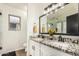 Bathroom featuring double sinks, granite countertops, white cabinetry, and a glass-enclosed shower at 3703 S 73Rd Dr, Phoenix, AZ 85043