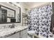 Well-lit bathroom featuring a granite countertop, decorative plants and sleek black fixtures at 3703 S 73Rd Dr, Phoenix, AZ 85043