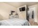 Bedroom featuring tile floors, a large window, an entertainment center, and a view to the bathroom at 3703 S 73Rd Dr, Phoenix, AZ 85043