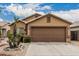 View of the home's exterior highlighting the garage, desert landscaping, and overall curb appeal at 3703 S 73Rd Dr, Phoenix, AZ 85043