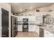 Modern kitchen with stainless steel appliances, white cabinets, granite countertops, and tile backsplash at 3703 S 73Rd Dr, Phoenix, AZ 85043