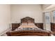 Inviting main bedroom with a large decorative wood bed frame, side tables, and tile flooring at 3703 S 73Rd Dr, Phoenix, AZ 85043