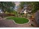 Beautiful backyard featuring a putting green, mature trees, and decorative lighting, perfect for outdoor relaxation at 3773 E Stampede Dr, Gilbert, AZ 85297