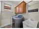 Well-equipped laundry room offers modern washer and dryer, utility sink, and ample storage with wood cabinets at 3773 E Stampede Dr, Gilbert, AZ 85297