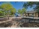 Community playground with swings, slides, and a covered picnic area surrounded by lush green trees in a park setting at 3773 E Stampede Dr, Gilbert, AZ 85297