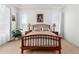 A bright bedroom featuring wood-look tile floors, a wood bed frame, and neutral decor at 3856 E Shannon St, Gilbert, AZ 85295