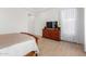 A bright bedroom with wood-look tile flooring, an entertainment center, and sheer curtains at 3856 E Shannon St, Gilbert, AZ 85295