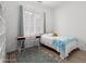 Small bedroom with wood-look floors, a desk, and a patterned area rug at 3856 E Shannon St, Gilbert, AZ 85295