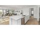 Open-concept kitchen with a large island, stainless steel dishwasher, and seamless flow into the living and dining areas at 3856 E Shannon St, Gilbert, AZ 85295