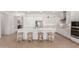 Contemporary kitchen featuring white cabinets, a spacious island with bar stools, and stainless steel appliances at 3856 E Shannon St, Gilbert, AZ 85295