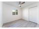 A minimalist bedroom featuring a large window, closet, and light gray flooring at 4033 W Sharon Ave, Phoenix, AZ 85029