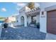Beautiful front entrance with covered seating area, desert plants, and brick-paved driveway leading to the garage at 4033 W Sharon Ave, Phoenix, AZ 85029
