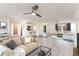 Open-concept living room featuring hardwood floors, neutral paint, ceiling fans, and modern furnishings at 4033 W Sharon Ave, Phoenix, AZ 85029