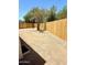 Spacious backyard featuring a new wood fence, gravel landscaping, and mature trees under a clear blue sky at 46 S 96Th St, Mesa, AZ 85208