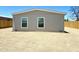 Rear exterior view of a well-maintained house featuring a simple design and side yard, with wooden fencing at 46 S 96Th St, Mesa, AZ 85208