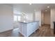 Modern kitchen with island featuring sleek countertops, ample storage, and seamless flow into the living area at 46 S 96Th St, Mesa, AZ 85208