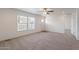 Inviting living room featuring neutral carpeting, a ceiling fan, and large windows that provide ample natural light at 46 S 96Th St, Mesa, AZ 85208