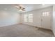 Bright living room featuring plush carpeting, a ceiling fan, and a welcoming front entrance for comfortable living at 46 S 96Th St, Mesa, AZ 85208