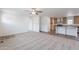 Open-concept living space with neutral tones, ceiling fan, carpet and hard surface flooring flowing into the kitchen area at 46 S 96Th St, Mesa, AZ 85208