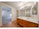 Well-lit bathroom boasting double sinks, vanity, and tile flooring with a view to Primary bedroom at 4804 S 25Th Dr, Phoenix, AZ 85041