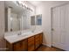 Bright bathroom with a double sink vanity, large mirror, and tiled floors at 4804 S 25Th Dr, Phoenix, AZ 85041
