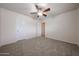 Carpeted bedroom with ceiling fan and two doors, providing ample space at 4804 S 25Th Dr, Phoenix, AZ 85041