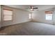Bright bonus room featuring neutral carpeting, multiple windows, and ceiling fan at 4804 S 25Th Dr, Phoenix, AZ 85041