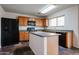 Updated kitchen with wood cabinets, island, black appliances, and stylish countertops at 4804 S 25Th Dr, Phoenix, AZ 85041