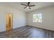 Spacious bedroom with hardwood floors, ceiling fan, and bright window view at 5096 S 245Th Dr, Buckeye, AZ 85326