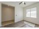View of a bedroom with an adjacent bathroom, large window and hardwood flooring at 5096 S 245Th Dr, Buckeye, AZ 85326