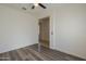 Light bedroom has an adjacent room, fan, large window and hardwood flooring at 5096 S 245Th Dr, Buckeye, AZ 85326