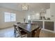 Bright dining room features a rustic wood table, modern chandelier, and flows to kitchen at 5096 S 245Th Dr, Buckeye, AZ 85326