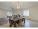 Bright dining room flows to living area featuring a modern chandelier and stylish table at 5096 S 245Th Dr, Buckeye, AZ 85326