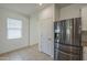 Stainless steel refrigerator in a kitchen with white cabinets and tiled floors at 5096 S 245Th Dr, Buckeye, AZ 85326