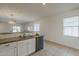 Kitchen sink with granite countertop next to stainless steel dishwasher and view into living area at 5096 S 245Th Dr, Buckeye, AZ 85326