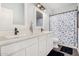 Updated bathroom with double sinks, a large mirror, and a blue and white floral shower curtain at 5321 N 196Th Ave, Litchfield Park, AZ 85340