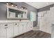 Modern bathroom featuring double sinks, white cabinets, and a luxurious walk-in shower at 5321 N 196Th Ave, Litchfield Park, AZ 85340