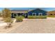 Charming blue home featuring well-maintained landscaping, solar panels, and a gravel yard for low maintenance at 5321 N 196Th Ave, Litchfield Park, AZ 85340