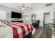 Bright main bedroom with a TV, ceiling fan, a large bed and a sitting chair at 5321 N 196Th Ave, Litchfield Park, AZ 85340