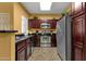 Kitchen featuring stainless steel appliances, dark cabinets, and tiled floors at 5335 E Shea Blvd # 1094, Scottsdale, AZ 85254