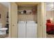 Convenient laundry closet with stacked washer and dryer and shelving for storage at 5335 E Shea Blvd # 1094, Scottsdale, AZ 85254