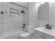 Bathroom with white fixtures including a vanity, toilet, and tiled tub/shower combo with black hardware at 546 N 96Th Pl, Mesa, AZ 85207