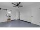 Bedroom featuring a ceiling fan, and open access to bathroom with sliding barn door at 546 N 96Th Pl, Mesa, AZ 85207