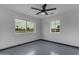 A simple bedroom with painted brick walls, a ceiling fan, and dual windows with views of the neighborhood at 546 N 96Th Pl, Mesa, AZ 85207