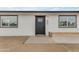 Close-up of a modern home featuring a dark front door, tidy landscaping, and a fresh exterior paint at 546 N 96Th Pl, Mesa, AZ 85207